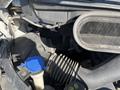 Engine compartment of a 2016 Ford Transit showing the air intake hose and fluid reservoir with a blue cap
