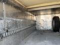 A 2015 Ford F-450 SD with an empty metal bed featuring diamond plate flooring and a spare tire mounted against the wall