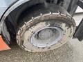 A close-up of a muddy tire on a 2011 Toyota 028FG15 forklift showing wear and tread pattern