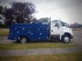 Side view of a 2012 International DuraStar 4300 commercial truck with a blue service body and chrome accents