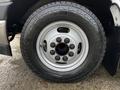 Close-up of a silver wheel and tire on a 2017 Chevrolet Express showing a five-lug pattern and the tire's tread designed for all-terrain use