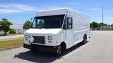 A white 2011 Ford Econoline truck with a boxy shape and large front windshield parked on a lot