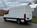 A white 2021 Mercedes-Benz Sprinter van positioned at an angle displaying its rear and side features with a cargo area and distinct Mercedes-Benz branding