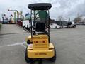 A yellow 2024 AGT Industrial KRW23 Mini Loader with a black seat and canopy facing away, equipped with large rubber wheels and rear lights