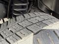Close-up of a tire tread on a 2010 Ford Econoline showing deep grooves and wear patterns on the rubber surface