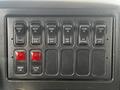 Control panel with multiple switches for functions like crane, clear warn, deck light, and strobe light along with red buttons for boom up and outrig out