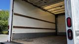 Interior view of a 2016 Isuzu NPR cargo area with wooden railings along the sides and a wooden floor