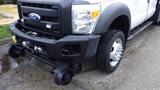 A white 2011 Ford F-550 with a black grill and bumper showcasing its front end and large wheels