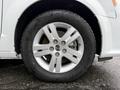 A close-up view of the wheel of a 2017 Dodge Grand Caravan featuring a silver alloy rim and a tire with noticeable tread depth