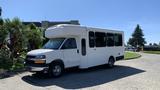 A white 2011 Chevrolet Express with a high roof and large windows designed for passenger transport