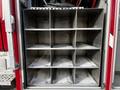 The image shows an empty metal storage compartment with twelve square sections designed for organizing equipment in a 1994 Freightliner FL80