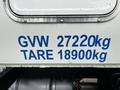 A white truck with blue text displaying GVW 27220kg and TARE 18900kg on the side