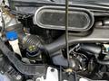 Close-up view of the engine compartment of a 2018 Ford Transit featuring components like an air intake hose and fluid reservoirs