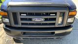 Front view of a blue 2013 Ford Econoline van highlighting the grille and the Ford logo