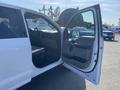 A white 2017 Ford F-150 with the driver's side door open revealing the interior and dashboard