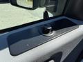 A dashboard panel of a 2014 Ford F-250 SD featuring a textured surface and a round black knob in the center