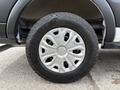 A close-up view of a wheel from a 2023 Ford Transit featuring a silver alloy rim with a Goodyear Wrangler tire