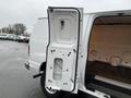 A white 2011 Ford Econoline van with an open side door revealing the interior cargo space