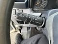 A steering column with a multifunction control lever featuring buttons for cruise control settings such as cancel, off, set, resume, and pass up