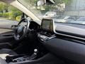 Interior view of a 2021 Toyota C-HR featuring a modern dashboard touchscreen and a gear shift positioned near the steering wheel