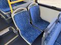 Two blue fabric bus seats with a star pattern are positioned next to each other in a public transit bus interior