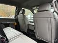 Interior seating of a 2022 Ford F-550 showing two gray leather seats and a center console viewed from the back seat area