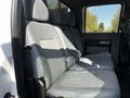 Interior view of a 2016 Ford F-550 showing the rear bench seat with gray fabric upholstery and seatbelts