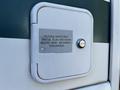 A door on a 2000 Ford Motorhome with a lock and a label stating potable water only sanitize flush and drain before using see instruction manual