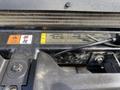 Close-up of a warning label on the engine compartment of a 2015 Ford F-550 featuring instructions and safety symbols for maintenance and coolant information