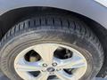 Close-up of a tire mounted on a 2014 Ford Escape featuring silver alloy wheels with a distinct tread pattern