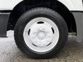 A close-up of a white wheel with a multi-bolt pattern mounted on a rugged black tire displaying tread patterns