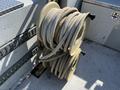 A stack of three large coiled hoses mounted on a metal reel
