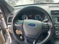 Steering wheel of a 2016 Ford Explorer featuring the Ford logo and control buttons for audio and cruise settings