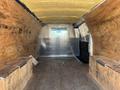 Interior of a 2012 Chevrolet Express cargo van with wooden flooring and walls lined with plywood and insulation on the ceiling