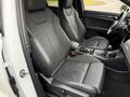 Interior of a 2024 Audi Q3 featuring two front leather seats with a modern design and a central console displaying controls and gear shifter