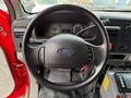Steering wheel of a 2007 Ford F-550 with Ford logo and control buttons visible, dashboard gauges and controls are in the background