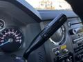 A close-up of the gear shift lever of a 2016 Ford F-550 including buttons for adjusting towing settings