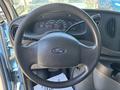 The interior view of a 2008 Ford E-350 showing the steering wheel and dashboard with gauges