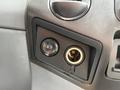 Close-up of a control panel featuring a button and a round power outlet on the dashboard of a 2017 Ford F-750