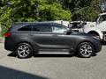 A 2017 Kia Sorento in gray with shiny alloy wheels and a side profile view