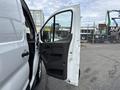 A 2023 Ford Transit van with the driver's side door open showcasing the interior door panel and handle