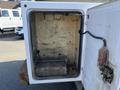 A 2015 Ford F-450 SD with an open storage compartment showing a metal framework and a wooden base inside