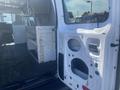 A 2009 Ford Econoline van with an open side door showing the interior cab and cargo area with white walls and a mesh partition