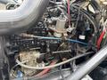 1998 Freightliner FL80 engine with various hoses and components including filters and valves interconnected within the engine compartment