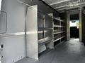 A 2023 Mercedes-Benz Sprinter van interior featuring metallic shelving units along one side designed for storage and organization