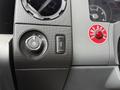 Close-up of the control panel in a 2013 Ford F-650 showing various dials and switches including a headlight control and a button for emergency features
