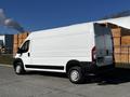 A white 2019 RAM Promaster van with large cargo space and side panel doors parked on a street