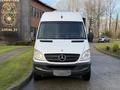 A 2012 Mercedes-Benz Sprinter van with a white exterior and the Mercedes-Benz logo on the front grille