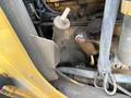 Close-up of a mechanical component of a 2011 John Deere 310SJ 4x4 Wheel Loader showing a lever and surrounding machinery elements
