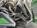 Close-up of a 2014 John Deere 1585 Terrain Cut mower showing the engine components and cooling system including pipes and hoses